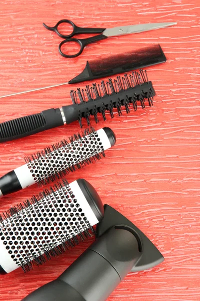 Kammen, borstels, haardroger en snijden shears, op een achtergrond met kleur — Stockfoto