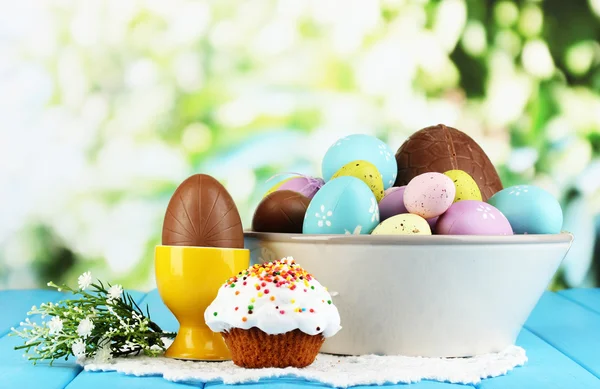 Samenstelling van Pasen en chocolade-eieren op houten tafel op natuurlijke achtergrond — Stockfoto