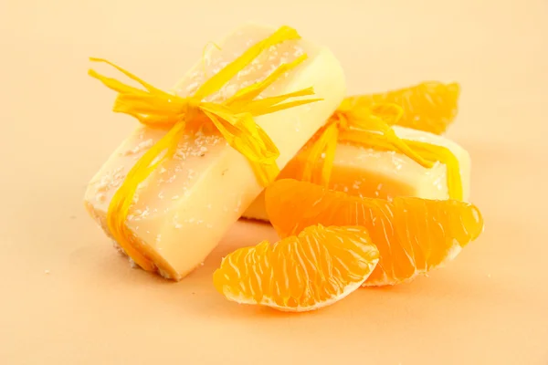 Jabón natural hecho a mano y naranja, sobre fondo beige — Foto de Stock