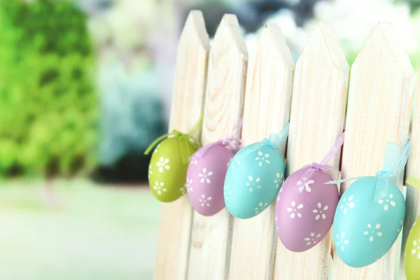 Art Easter background with eggs hanging on fence — Stock Photo, Image