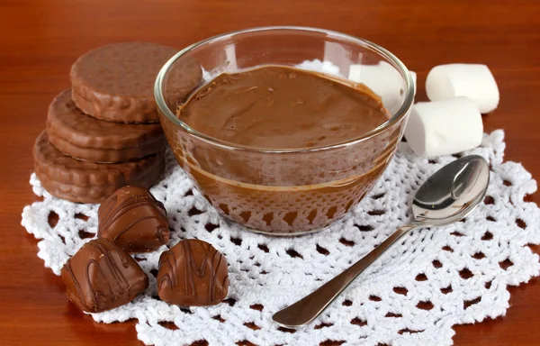 Kom van chocolade en snoepgoed op houten achtergrond — Stockfoto