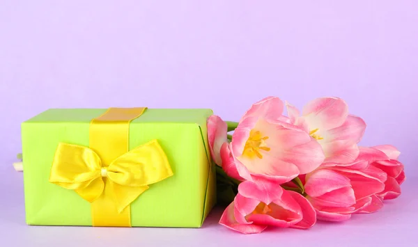 Rosa Tulpen und Geschenkbox, auf farbigem Hintergrund — Stockfoto