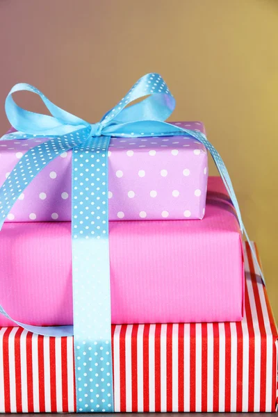 Gift box tied with a ribbon on a color background — Stock Photo, Image