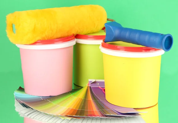 Set pour peinture : pots de peinture, rouleau de peinture, palette de couleurs sur fond vert — Photo