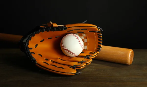 Baseball handske, bat og bold på mørk baggrund - Stock-foto
