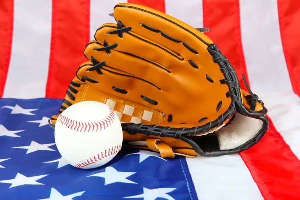 Guante de béisbol y pelota sobre fondo de bandera estadounidense — Foto de Stock