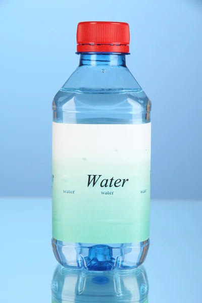 Wasserflasche mit Etikett auf blauem Hintergrund — Stockfoto