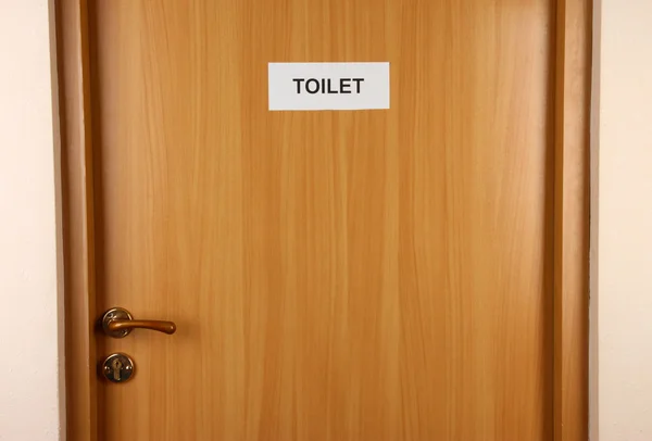 Segno di toilette sulla porta di legno — Foto Stock