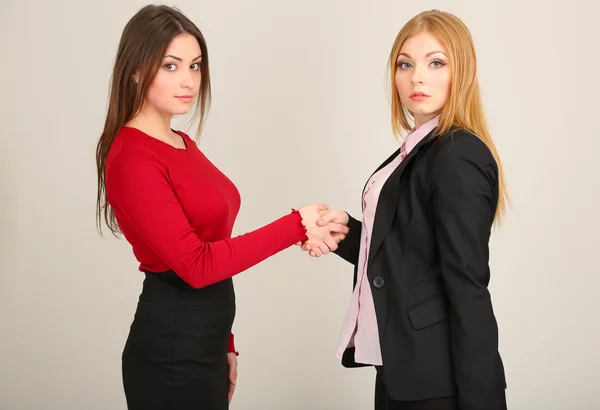 Duas mulheres de negócios em fundo cinza — Fotografia de Stock
