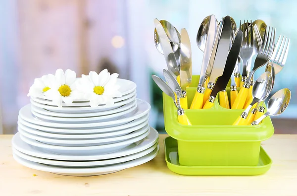 Placas, tenedores, cuchillos, cucharas y otros utensilios de cocina sobre fondo brillante —  Fotos de Stock