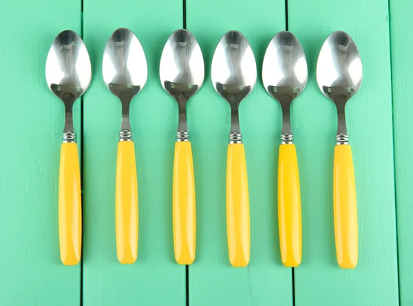 Dessert spoons on color wooden background — Stock Photo, Image