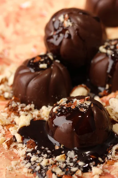 Schokoladenbonbons mit Nüssen, auf farbigem Hintergrund — Stockfoto