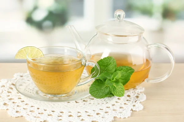 Xícara de chá com hortelã e limão na mesa no quarto — Fotografia de Stock