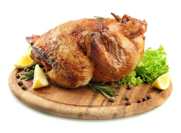 Целый жареный цыпленок на деревянной тарелке с лимоном, изолированный на белом — стоковое фото