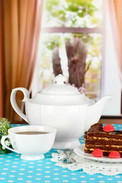 茶壶、 杯茶和美味的蛋糕上窗口背景 — 图库照片