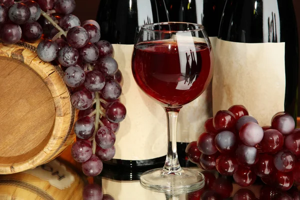 Composição de vinho, barril de madeira e uva, sobre fundo vermelho escuro — Fotografia de Stock