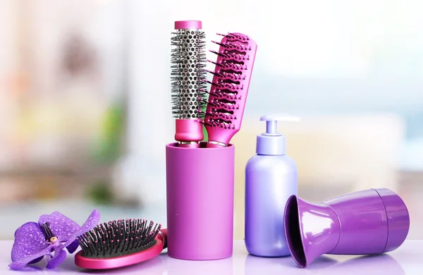 Hair brushes, hairdryer and cosmetic bottle in beauty salo — Stock Photo, Image