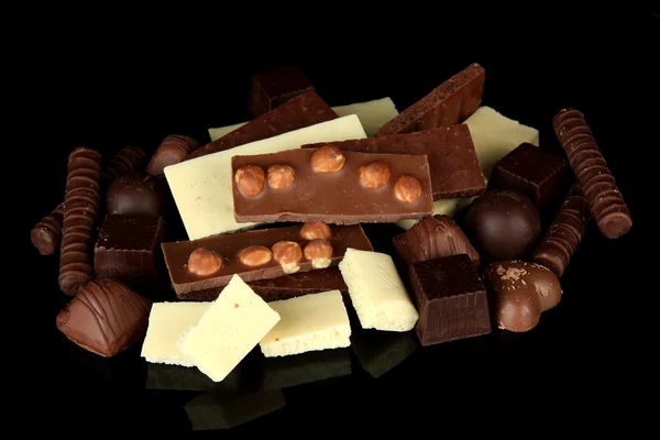 Schokolade und Süßigkeiten isoliert auf schwarz — Stockfoto