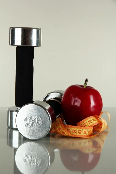 Dambıl ile elma ve gri arka plan üzerinde santimetre — Stok fotoğraf