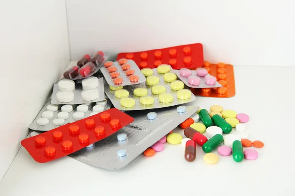 Barevné tablety a kapsle na polici — Stock fotografie