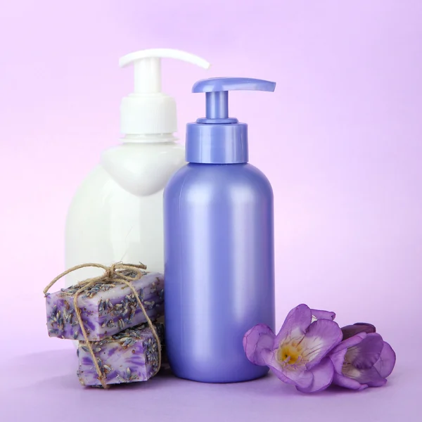 Liquid and hand-made soaps on purple background — Stock Photo, Image