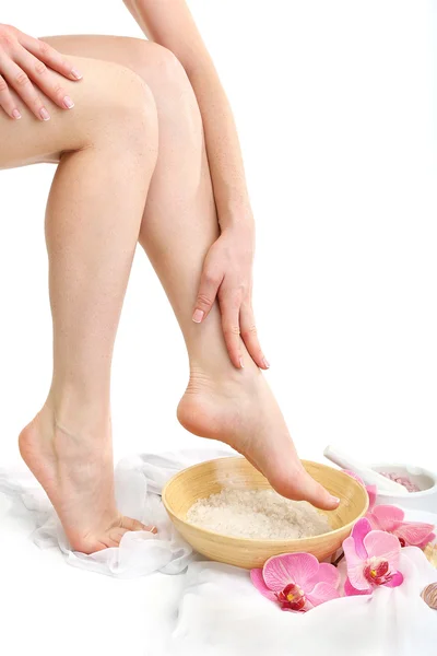 Female feet in spa bowl with sea salt, isolated on white — Stock Photo, Image