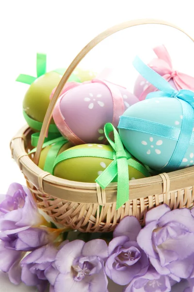 Bright easter eggs with bows in basket, isolated on white — Stock Photo, Image