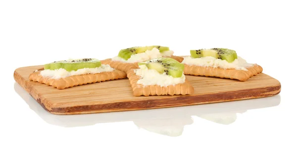 Knäckebröd met kaas en kiwi, op snijplank, geïsoleerd op wit — Stockfoto