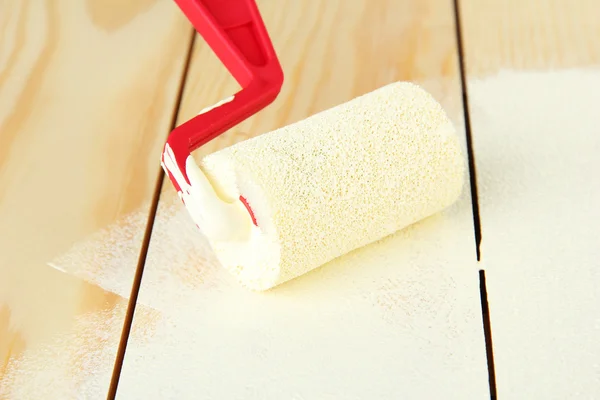 Paint roller brush with white paint, on wooden background — Stock Photo, Image