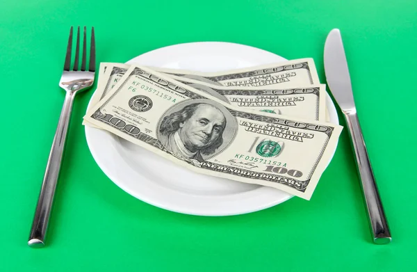 Dinero en plato sobre fondo verde — Foto de Stock