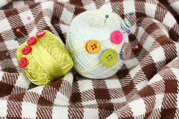 Buttons of different colors, and the two tangle thread on checked plaid