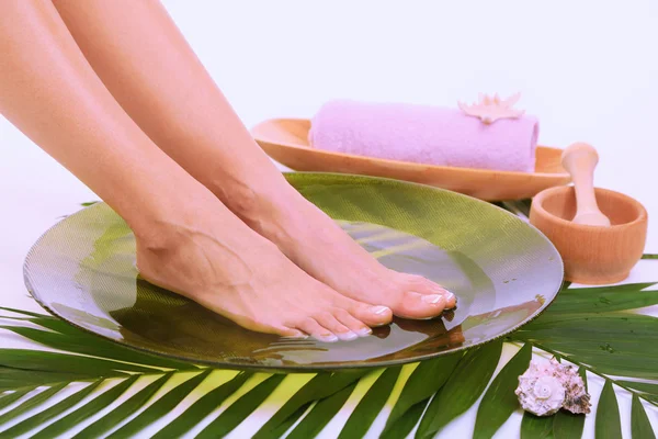 Pies femeninos en cuenco de spa con agua, aislados en blanco —  Fotos de Stock