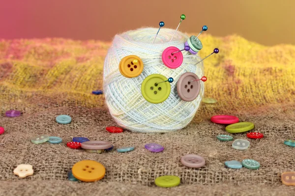 Ball of thread in the buttons on a colorful background — Stock Photo, Image