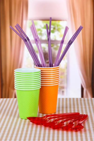 Пластиковые чашки, ложки различных цветов на ярком фоне — стоковое фото