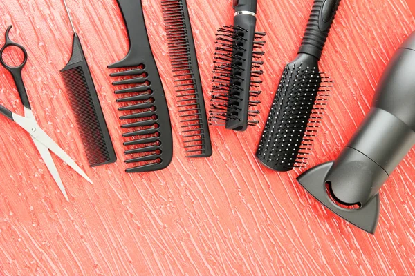 Kammen, borstels, haardroger en snijden shears, op een achtergrond met kleur — Stockfoto