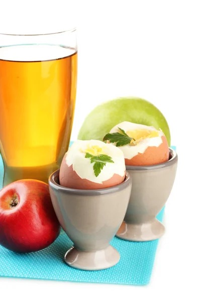 Leichtes Frühstück mit gekochten Eiern und einem Glas Saft, isoliert auf weiß — Stockfoto