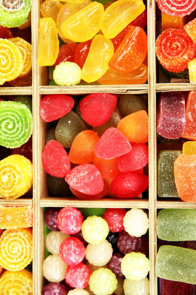 Multicolor candies in wooden box, close up