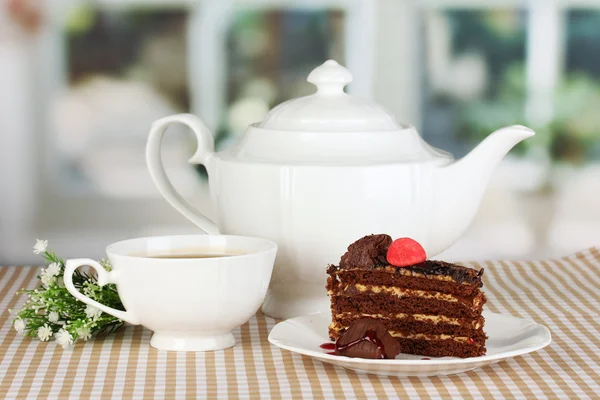 Tetera, taza de té y delicioso pastel en el fondo de la ventana — Foto de Stock