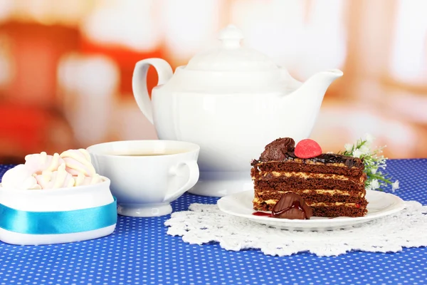 Teekanne, Tasse Tee und leckerer Kuchen auf dem Zimmer Hintergrund — Stockfoto
