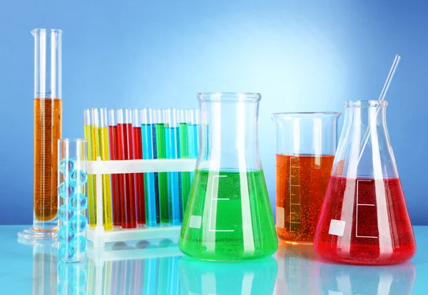 Test tubes with colorful liquids on blue background — Stock Photo, Image