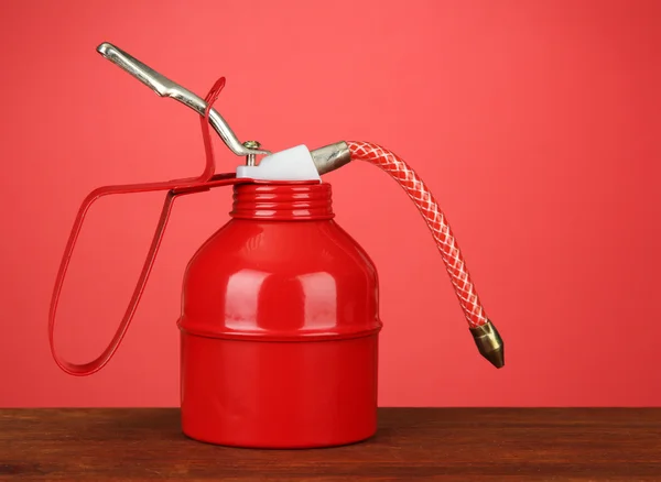 Lata de aceite sobre fondo rojo — Foto de Stock