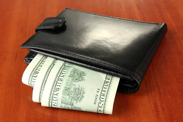 Wallet with hundred dollar banknotes, on wooden background — Stock Photo, Image