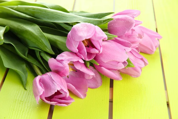 Mooi boeket van paarse tulpen op groene houten achtergrond — Stockfoto
