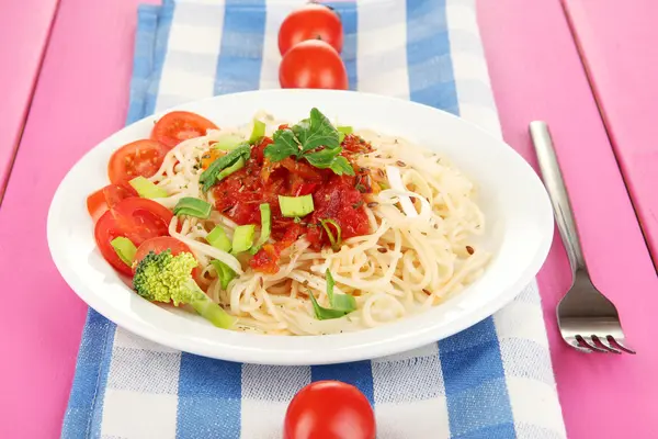 Smaczne spaghetti z sosem i warzywami na tabliczce na drewniany stół szczegół — Zdjęcie stockowe