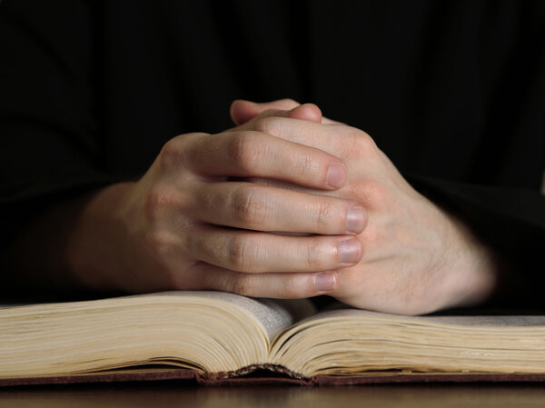 Priest reading from the holy bible, close up