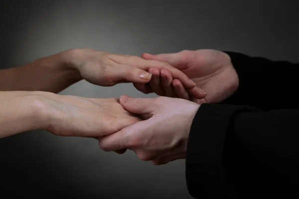 Priest holding woman hands, on black background — Stock Photo, Image