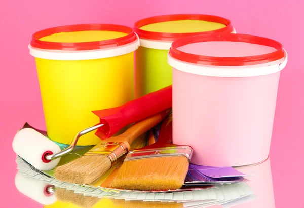Instellen voor schilderij: schilderen potten, penselen, verf-roller, palet van kleuren op roze achtergrond — Stockfoto