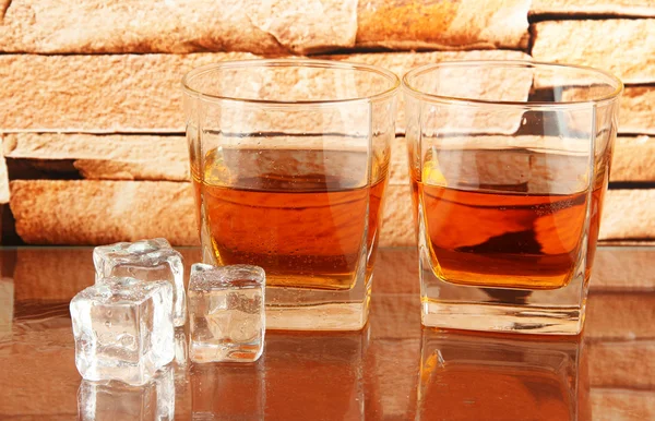 Gläser Whiskey und Eis auf Backsteinmauer Hintergrund — Stockfoto