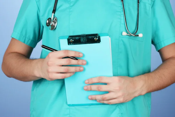 Mão de médico com prescrição em branco, em fundo azul — Fotografia de Stock