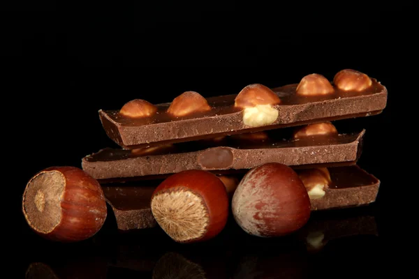 Schokolade mit Nüssen, isoliert auf schwarz — Stockfoto